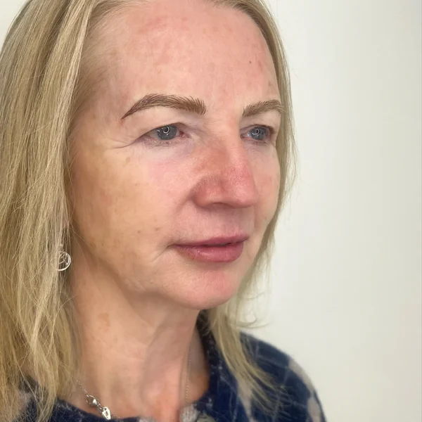 3D feather brows on mature blonde client — soft warm tone, age-appropriate result