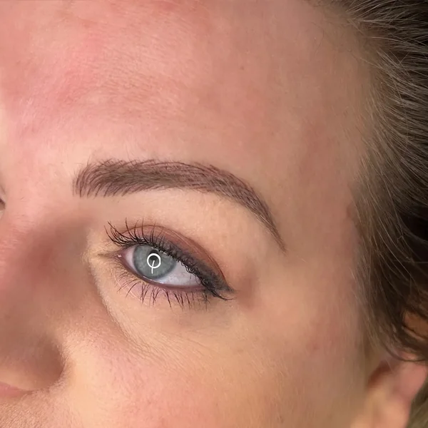 Fresh eyeliner tattoo on mature blue eyes — overhead view post-treatment
