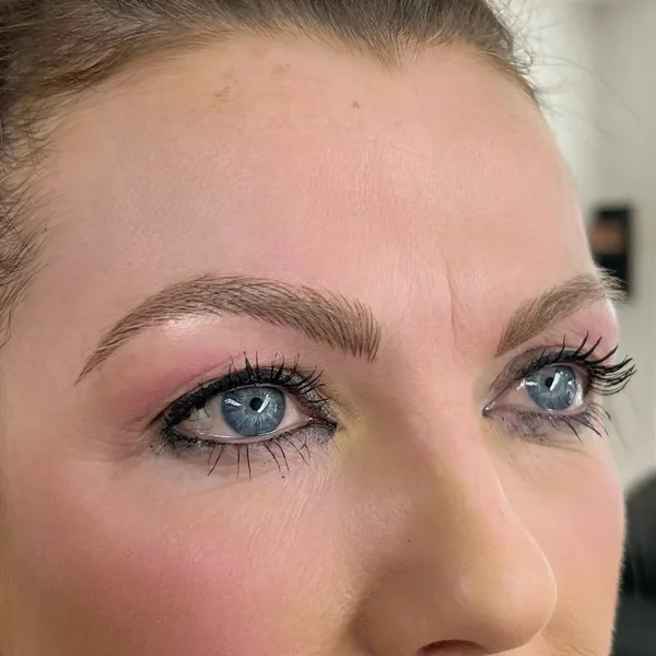 Winged eyeliner tattoo on mature blonde — defined lifted eye result